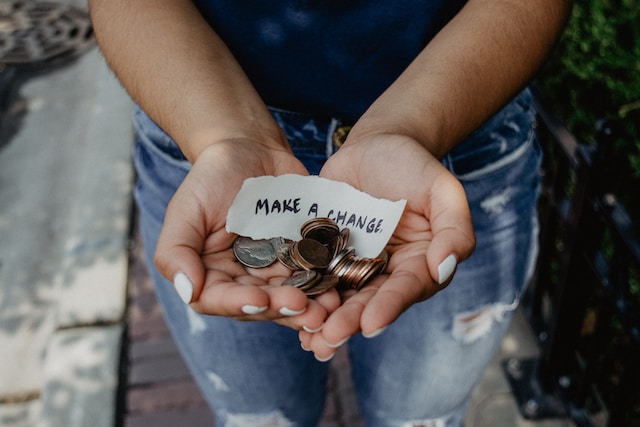 Close up shot of woman holding change in her hands. A charity image that illustrates PSAs or public service announcements.